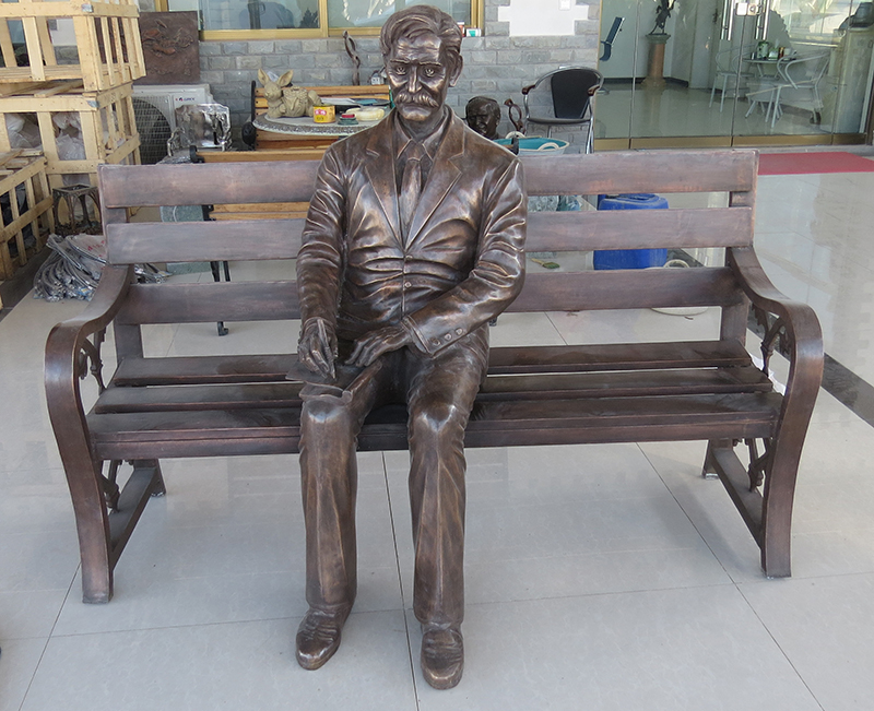 Cast bronze life size one man sits on a bench