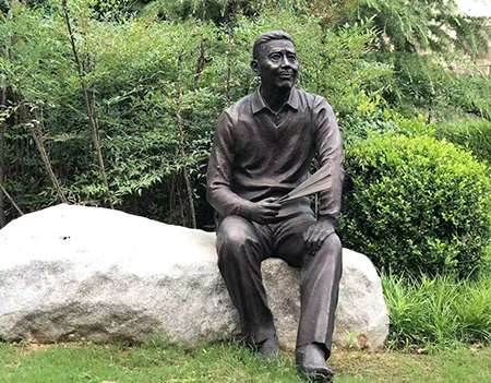 Cast bronze life size one man sits on a chair/stone