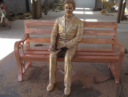 Cast bronze life size one man sits on a bench