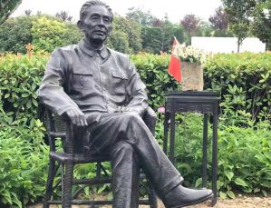 Cast bronze life size one man sits on a chair/stone