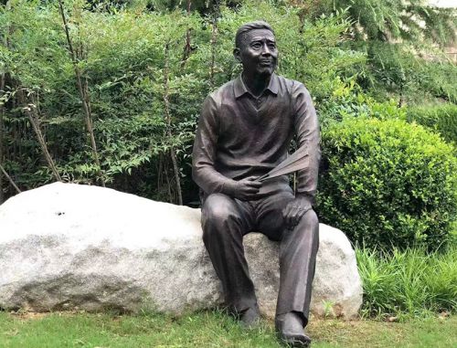 Cast bronze life size one man sits on a chair/stone